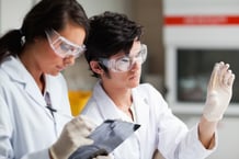 Concentrate science students looking at Petri dish in a laboratory-1