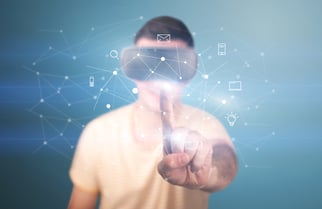 Young impressed man wearing virtual reality goggles with mixed media icons around his finger-3
